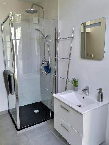 une salle de bain blanche avec une douche et un lavabo dans l'établissement L'ATELIER - 500m Musée BD, à Angoulême