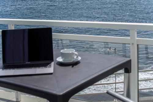 laptopa na stole na balkonie z widokiem na ocean w obiekcie Acapulco Ocean View w mieście San Agustin