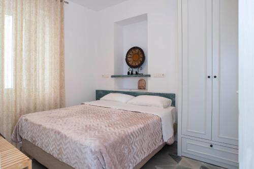 a bedroom with a bed and a clock on the wall at Nestor's house in Pylos