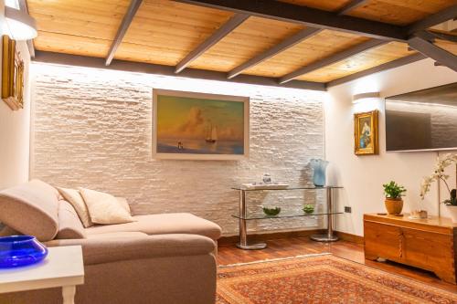 ein Wohnzimmer mit einem Sofa und einem TV in der Unterkunft Elena Casa Turistica in Padua