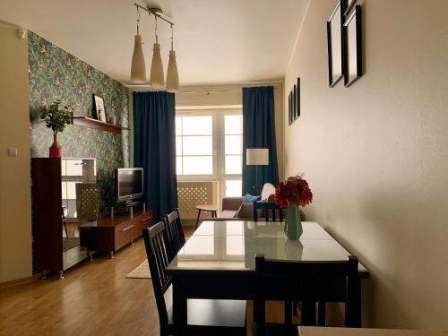 comedor y sala de estar con mesa y sillas en Apartament Fabian, en Władysławowo