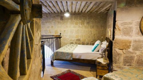 a bedroom with a bed in a stone wall at Pigeon Hotel Cappadocia in Uchisar