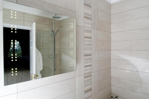 a bathroom with a shower and a mirror at Tyn Rhos Country House in Caernarfon