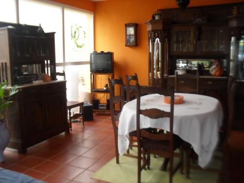 a dining room with a table and chairs and a tv at Quinta do Outeiro Alto in Constância