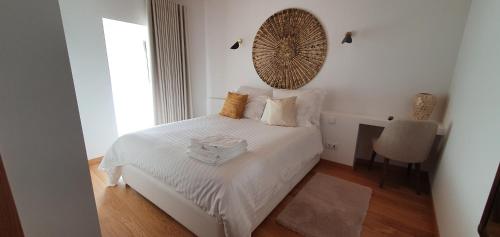 a bedroom with a white bed with a mirror on the wall at Casas de Campo da Barroca in Tabosa