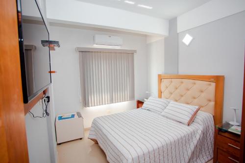 a bedroom with a bed and a television in it at Asuncion Soho - Departamentos in Asunción