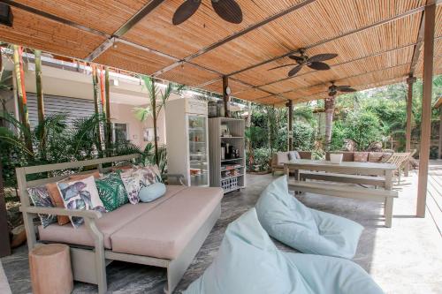 a covered patio with a couch and a table at Tamarindo Bay Boutique Hotel, Apartments & Suites in Tamarindo