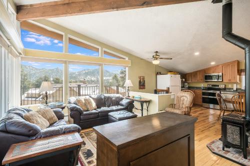 a living room with couches and a kitchen with a view at Starlight In The Rockies in Estes Park