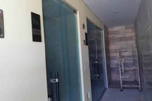 Puerta de cristal en una habitación con ducha a ras de suelo en Apartamento en edificio full, Rodadero Santa Marta, en Gaira