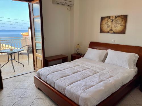 a bedroom with a large bed with a balcony at Sofotel in Koroni