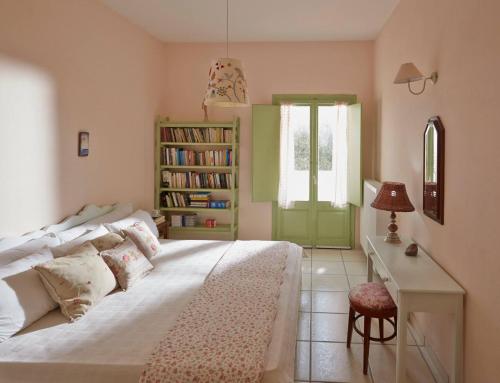 a bedroom with a bed and a desk and a window at Flower and Crafts - The Eco Nature House in Monolithos