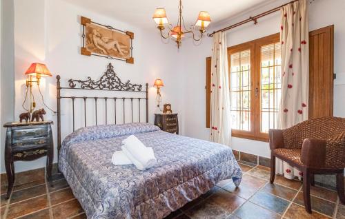1 dormitorio con 1 cama, 1 silla y 1 ventana en 7 Bedroom Stunning Home In Frigiliana, en Acebuchal