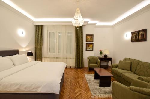 ein Schlafzimmer mit einem Bett, einem Sofa und einem Tisch in der Unterkunft Crown apartment - Your most comfortable stay in Belgrad