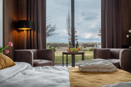 Habitación de hotel con cama y ventana grande en Riverwood Relax Park en Moshny