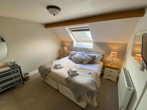 a small bedroom with a bed with a window at Meadowside Cottage in Bassenthwaite Lake
