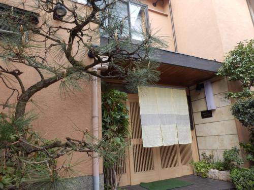 a front door of a building with a tree at Kikunoya Ryokan in Kanazawa