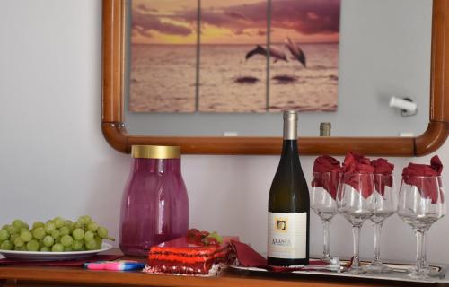 a bottle of wine and wine glasses on a table at Ephelia gold in Laganas