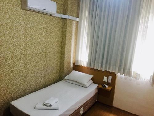 a small bed in a room with a window at Hotel GMatos Belo Horizonte - Próximo a Rodoviária e Mercados Turísticos in Belo Horizonte