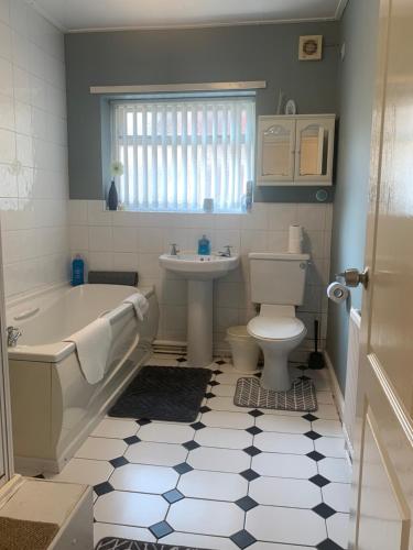 a bathroom with a tub and a toilet and a sink at Be My Guest Liverpool - Ground Floor Apartment with Parking in Liverpool