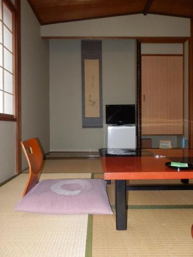 a living room with a table and a microwave at Kikunoya Ryokan in Kanazawa