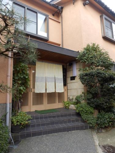 a house with a brick walkway in front of it at Kikunoya Ryokan in Kanazawa