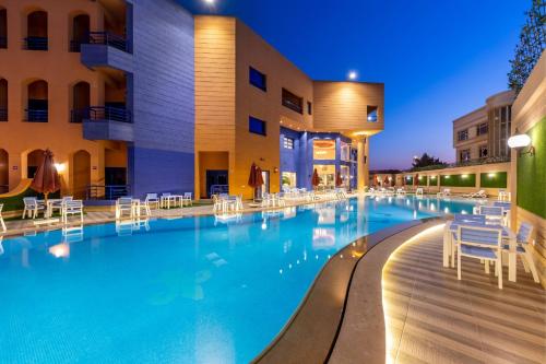 a swimming pool in front of a hotel at night at Royal Day Plaza Hotel in 6th Of October