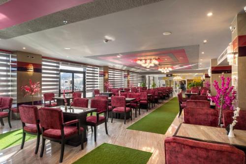 a restaurant with red chairs and tables in a room at Royal Day Plaza Hotel in 6th Of October