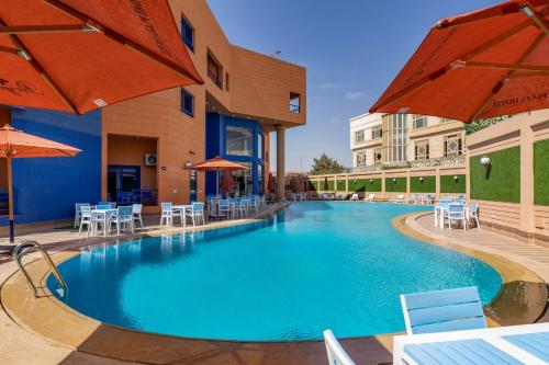 a pool at a hotel with chairs and umbrellas at Royal Day Plaza Hotel in 6th Of October