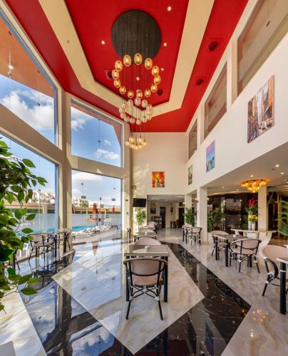 a large lobby with tables and chairs and a chandelier at Royal Day Plaza Hotel in 6th Of October