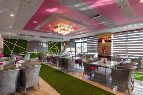 a restaurant with tables and chairs and purple ceilings at Royal Day Plaza Hotel in 6th Of October