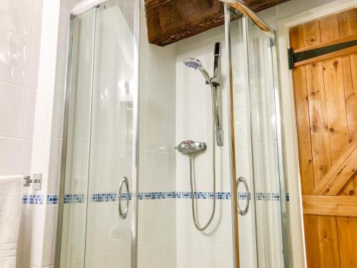 a shower with a glass door in a bathroom at Hillfort in Ruthin
