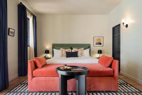 a bedroom with a bed and a red couch at Casa Cody in Palm Springs