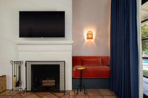 a living room with a red couch and a fireplace at Casa Cody in Palm Springs