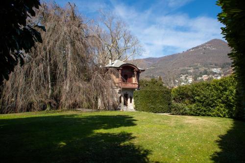 una piccola casa in un giardino con un albero di Villino liberty a Cernobbio