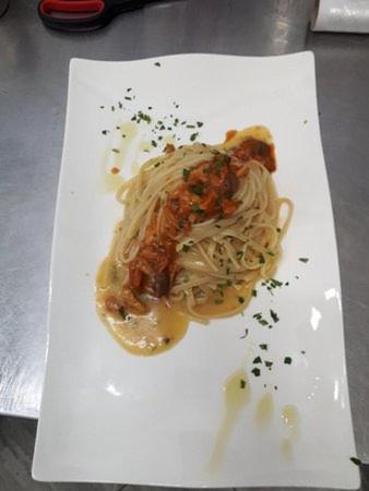 a white plate with spaghetti and sauce on it at B&B Brezza Marina & Ristorante Shoreline in Pozzallo