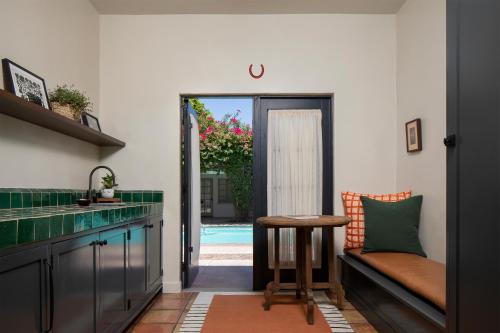 a kitchen with a bench and a table and a pool at Casa Cody in Palm Springs