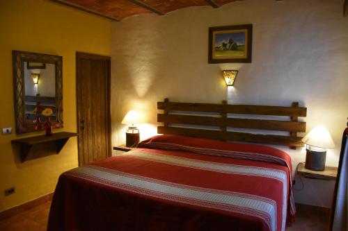 a bedroom with a bed and two lamps and a mirror at Hotel Mi Pueblito Tapalpa in Tapalpa