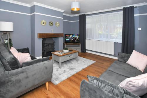 sala de estar con 2 sofás y chimenea en Orion House - sleeps 6, driveway, garden en Crewe