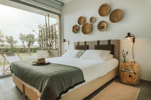 a bedroom with a bed and a large window at Herdade da Rocha - Boutique Lodge in Crato