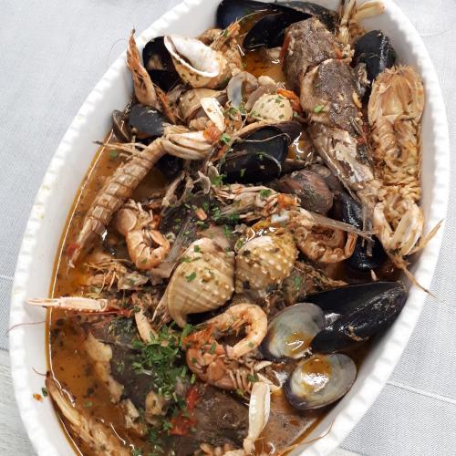 a white bowl of food with shrimp and mussels at B&B Brezza Marina & Ristorante Shoreline in Pozzallo