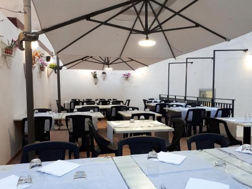 a dining room with white tables and chairs at B&B Brezza Marina & Ristorante Shoreline in Pozzallo