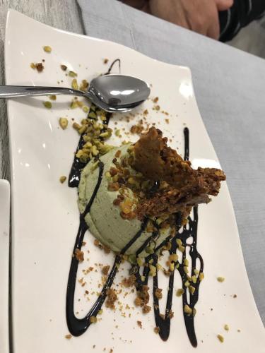 a dessert on a white plate with a spoon at B&B Brezza Marina & Ristorante Shoreline in Pozzallo