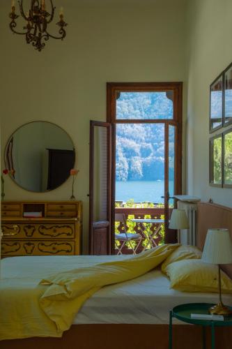 a bedroom with a bed and a mirror and a window at Villino liberty in Cernobbio