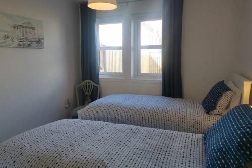 a bedroom with two beds and a window at The Moorings, 2 bed apartment with private garden. in Anstruther