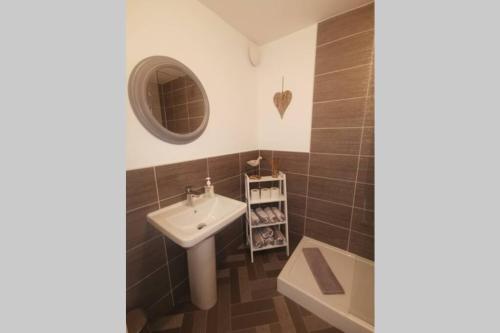 a bathroom with a sink and a mirror at The Moorings, 2 bed apartment with private garden. in Anstruther