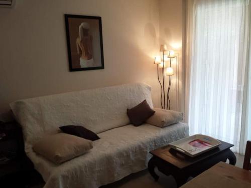 un salon avec un canapé blanc et une table dans l'établissement Coin tranquille à 2km de Saint-Florent, à Oletta