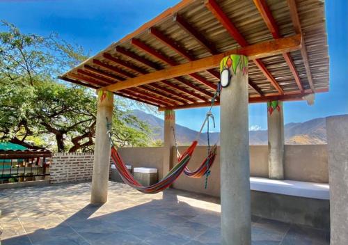 a porch with a hammock under a wooden roof at Hostal Aurora, Smith Lodging in Taganga
