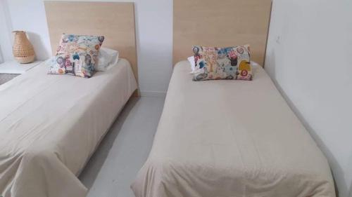 two beds in a room with white sheets and pillows at Águeda Hostel & Friends in Águeda