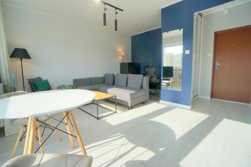 ein Wohnzimmer mit einem Sofa und einem Tisch in der Unterkunft Przytulne mieszkanie w Sopocie in Sopot