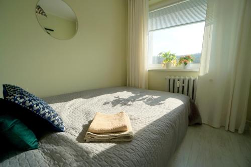 ein Schlafzimmer mit einem Bett und einem Handtuch darauf in der Unterkunft Przytulne mieszkanie w Sopocie in Sopot